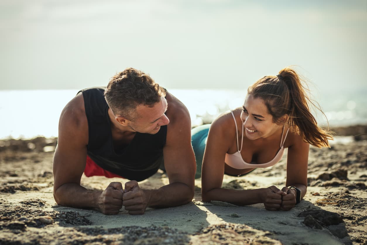 Active couple exercising on the beach